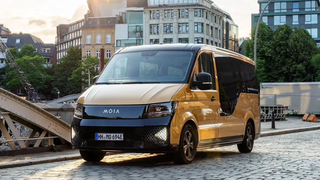 Ein goldener Kleinbus mit der Aufschrift "MOIA" fährt über eine Hamburger Straße.