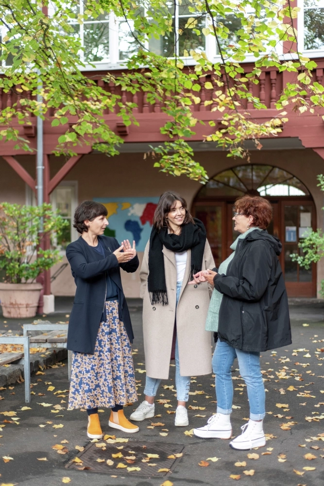 Drei Frauen unterhalten sich in Gebärdensprache miteinander.