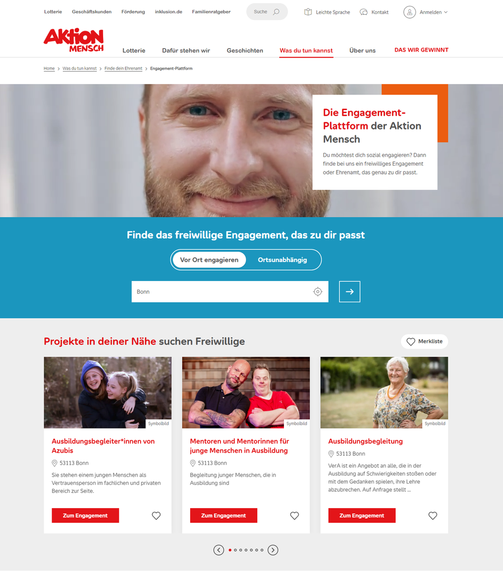 Ein Screenshot der Engagement-Plattform der Aktion Mensch. Oben ist das Foto eines lächelnden Mannes zu sehen, darunter steht auf hellblauem Hintergrund der Text "Finde das freiwillige Engagement, das zu dir passt". Noch weiter unten sind drei Teaser zu Engagementangeboten mit roten Buttons zu sehen.