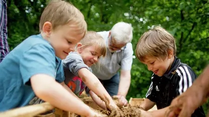 Kinder matschen im Lehm.