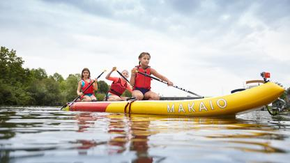 Drei Kinder in einem Kanu.