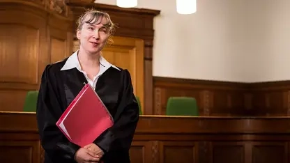 Blinde Rechtsanwältin in Robe im Gerichtssaal