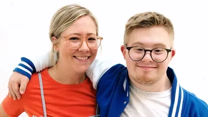 Die beiden Geschwister Tabea und Marian lächeln Arm in Arm in die Kamera.