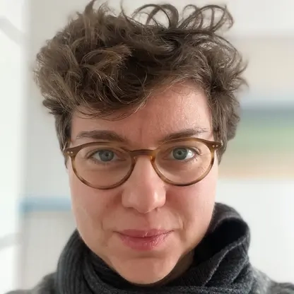 Portraitfoto von Franziska Seehausen. Sie hat kurze lockige Haare und trägt eine Brille.