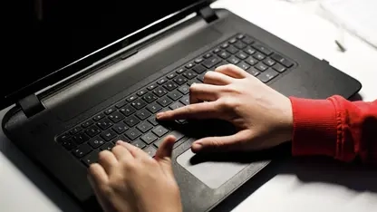 Eine Laptop-Tastatur, darauf zwei Hände.