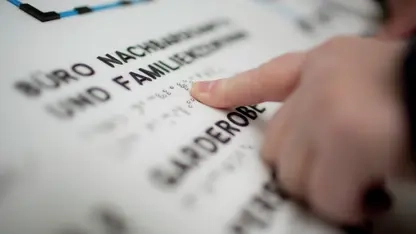 Eine Kinderhand liest einen Text in Brailleschrift.