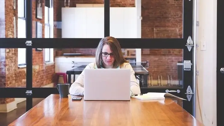 Eine Frau arbeitet an einem Laptop.