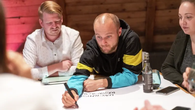 Ein Team arbeitet gemeinsam an einem Tisch zusammen