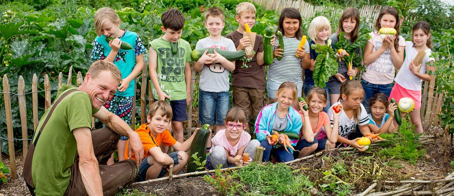 Teilnehmer eines Gartenprüjektes präsentieren ihre Ernte