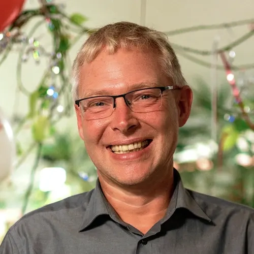 Gewinner Tobias steht in seinem Wohnzimmer und lacht in die Kamera. 