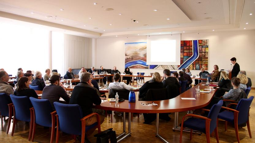 Viele Menschen sitzen an einem Konferenztisch.