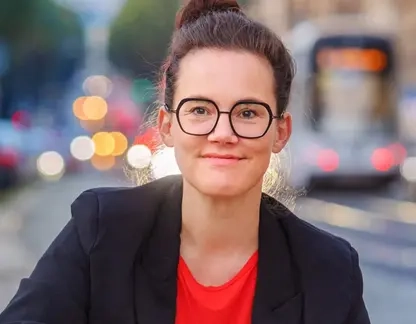 Junge Frau mit hochgesteckten dunklen Haaren und großer Brille