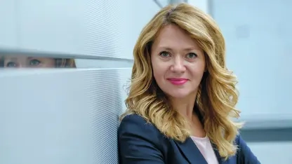 Olga Nevska, eine Frau mit langen blonden Haaren und pinkem Lippenstift.