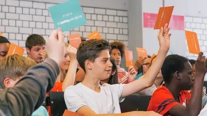 Schüler*innen melden sich mit bunten Postkarten in den Händen.