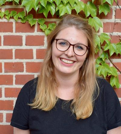 Len Groh-Trautmann - eine junge Frau mit langen blonden Haaren und Brille.