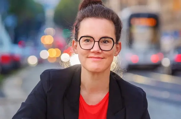 Junge Frau mit hochgesteckten dunklen Haaren und großer Brille