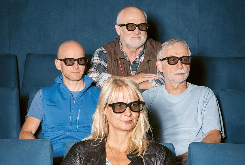 Vier Personen mit 3D Brillen sitzen in Kinosesseln