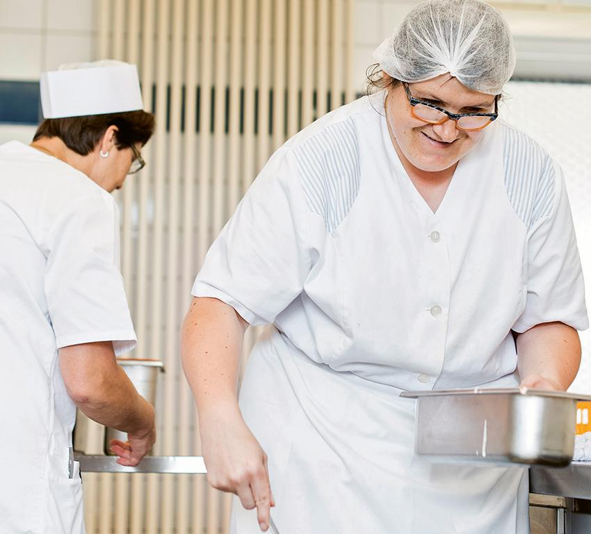 Zwei Frauen arbeiten in einer Großküche