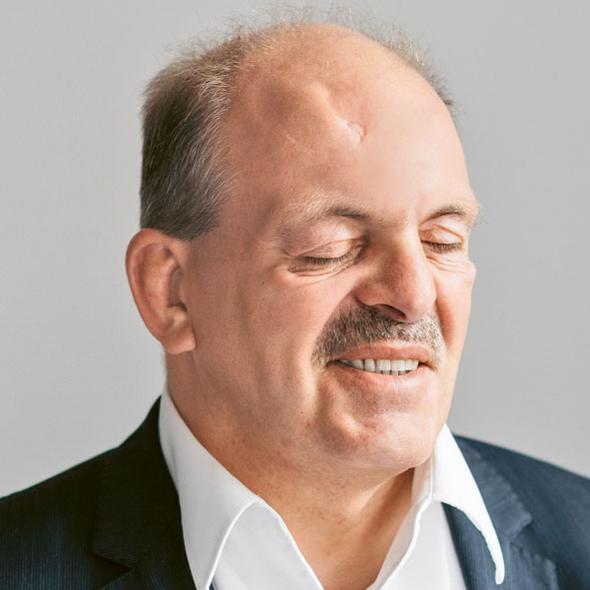 Lächelnder Mann mit Schnauzbart, die Augen sind geschlossen. 