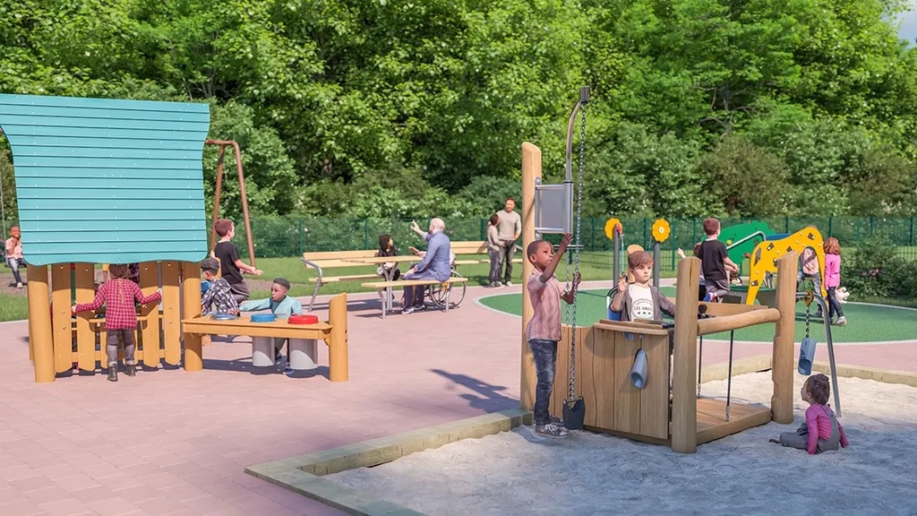 Kinder mit und ohne Behinderung an befahrbarem Sandkasten und barrierefreiem Häuschen. Im Hintergrund sitzen Eltern an einem Tisch.