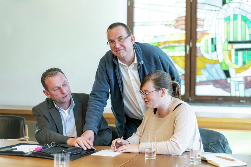 Drei Menschen im Raatssaal von Schneverdingen