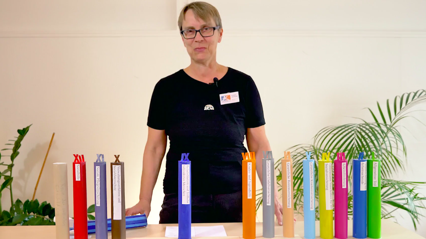 Eine Frau mit Brillen und kurzen Haaren steht vor einem Schreibtisch