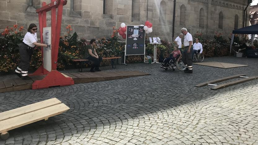 Ein Mädchen fährt mit dem Rollstuhl über einen Rollstuhl-Parcours 