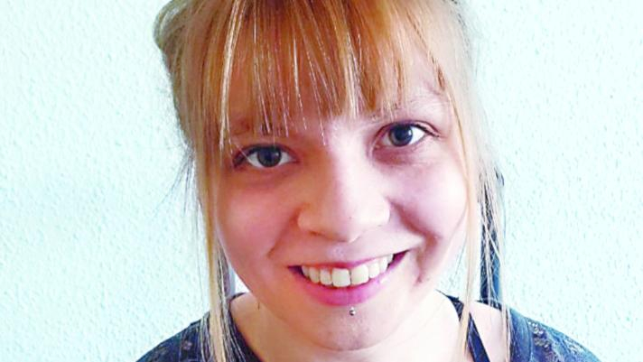 Eine lächelnde junge Frau mit blondem Pony